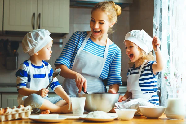 Lycklig familj i köket. mor och barn förbereder degen, ba — Stockfoto