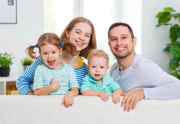 Mutlu aile gülüyor ve evde kanepede sarılma — Stok fotoğraf