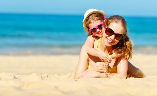 Happy family mother and child daughter  on beach in summer — Stock Photo, Image