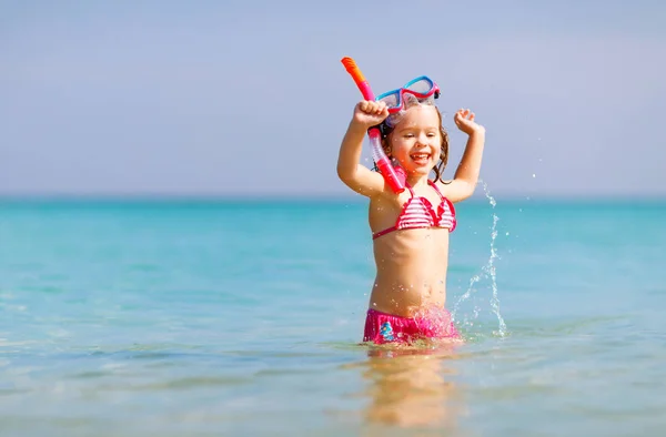 Happy child girl in a mask on the beach — Stock Photo, Image
