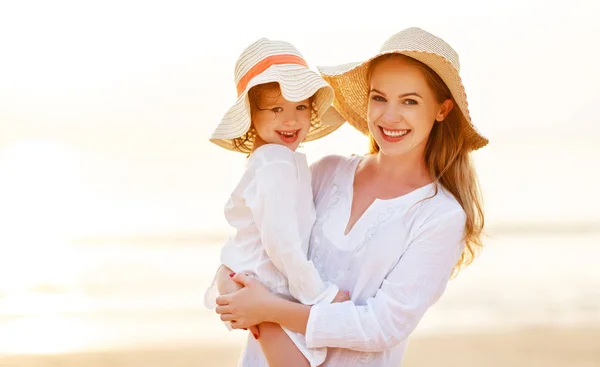 Happy family at beach. mother and child daughter hug at sunset — Stock Photo, Image