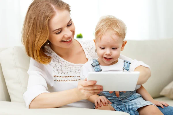 Mor och baby son med en Tablet PC-dator hemma — Stockfoto