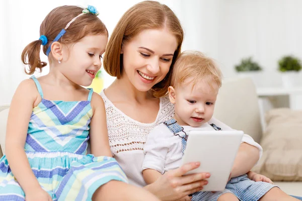 Madre e hijos con una tableta en casa — Foto de Stock