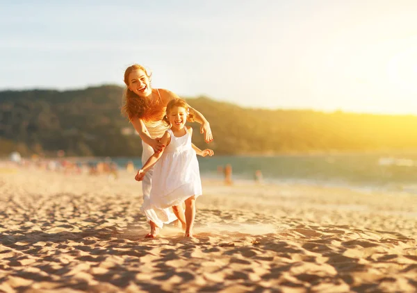 Happy family  mother and daughter run, laugh and play at beach — Stock Photo, Image