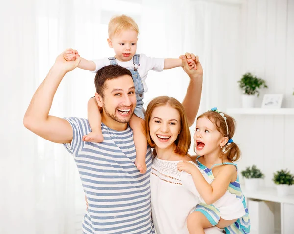 Счастливая семья смеется и обнимается дома на диване — стоковое фото