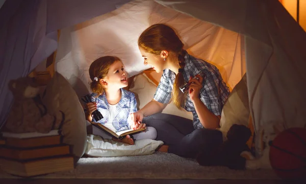 Mãe e filha filha com um livro e uma lanterna antes de ir — Fotografia de Stock