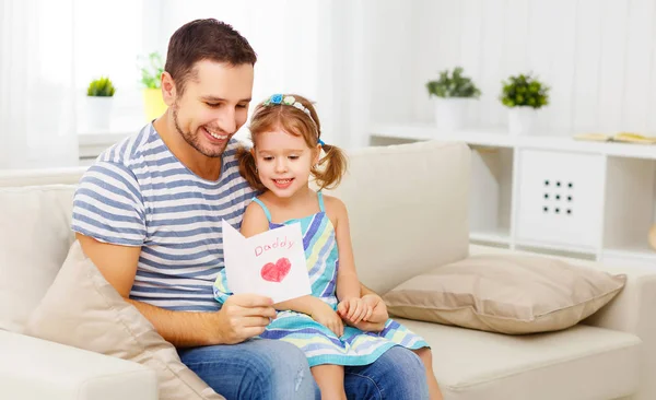 Father's day. Happy family daughter giving dad a greeting card on holida