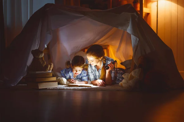 Мати і дитина дочка з книгою і ліхтариком, перш ніж йти — стокове фото