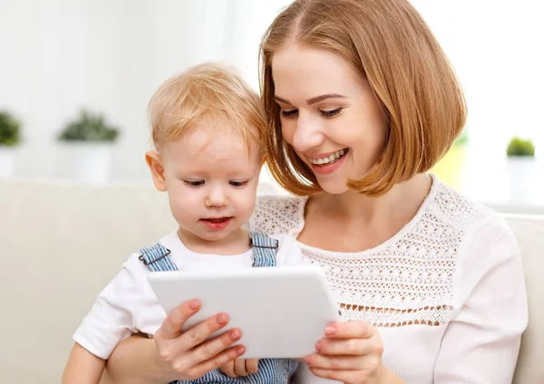 Madre e hijo pequeño con una tableta en casa — Foto de Stock