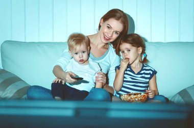 Aile anne ve çocuk evde televizyon izlerken 