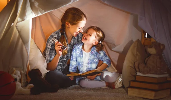 Mãe e filha filha com um livro e uma lanterna antes de ir — Fotografia de Stock