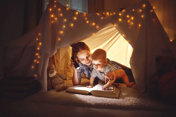 Moeder en baby zoon met een boek en een zaklamp voordat u naar — Stockfoto