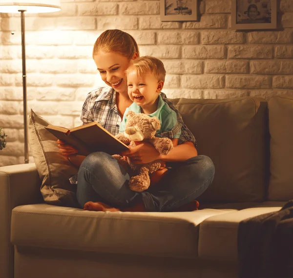 Family before going to bed mother reads to her baby son book nea — Stock Photo, Image