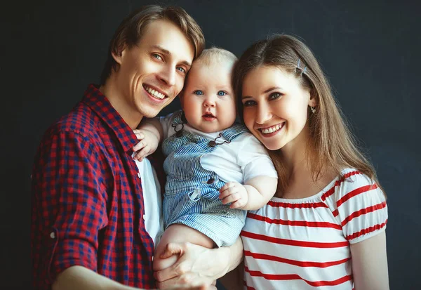 Lycklig familj far mor och baby son på svart bak — Stockfoto