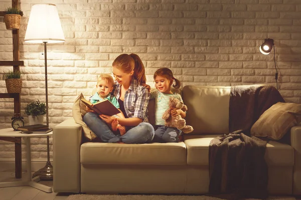 Family before going to bed mother reads children book about lamp — Stock Photo, Image