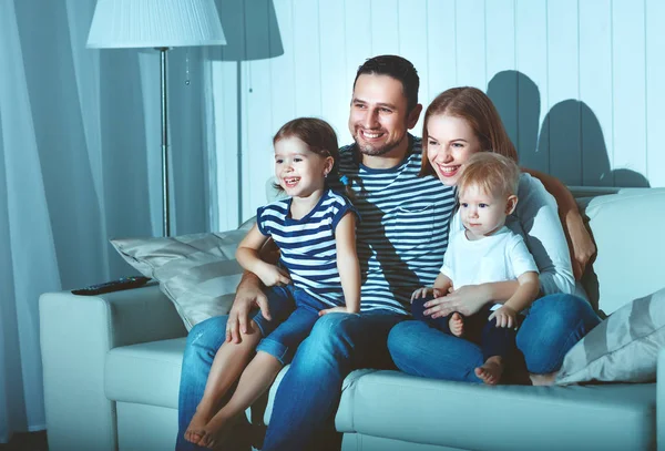 Rodina sleduje televizi doma na pohovce — Stock fotografie