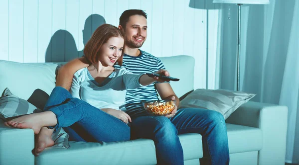 Família casal assistindo televisão em casa no sofá — Fotografia de Stock