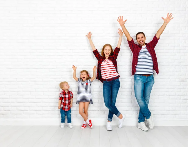 Ευτυχισμένη οικογένεια μητέρα, πατέρας, γιος, κόρη της ένα λευκό κενό τοίχο — Φωτογραφία Αρχείου