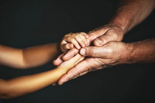 Концепция поколений. Рука ребенка и пожилого персо — стоковое фото