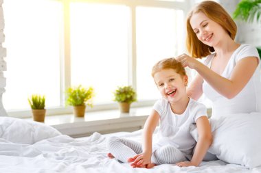 Anne penye saç kız yatakta