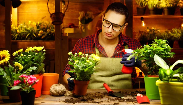 Homme heureux jardinier transplantation et arrosage des fleurs — Photo