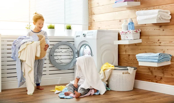 Счастливые дети мальчик и девочка в прачечной нагрузки стиральная машина — стоковое фото