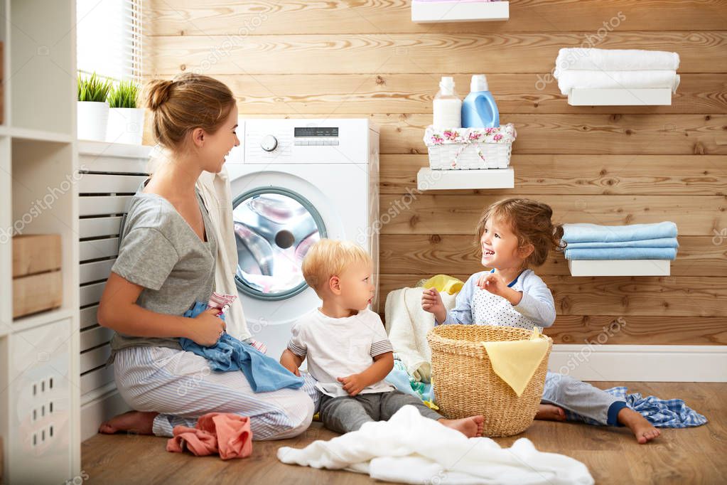 Happy family mother   housewife and children in   laundry load w