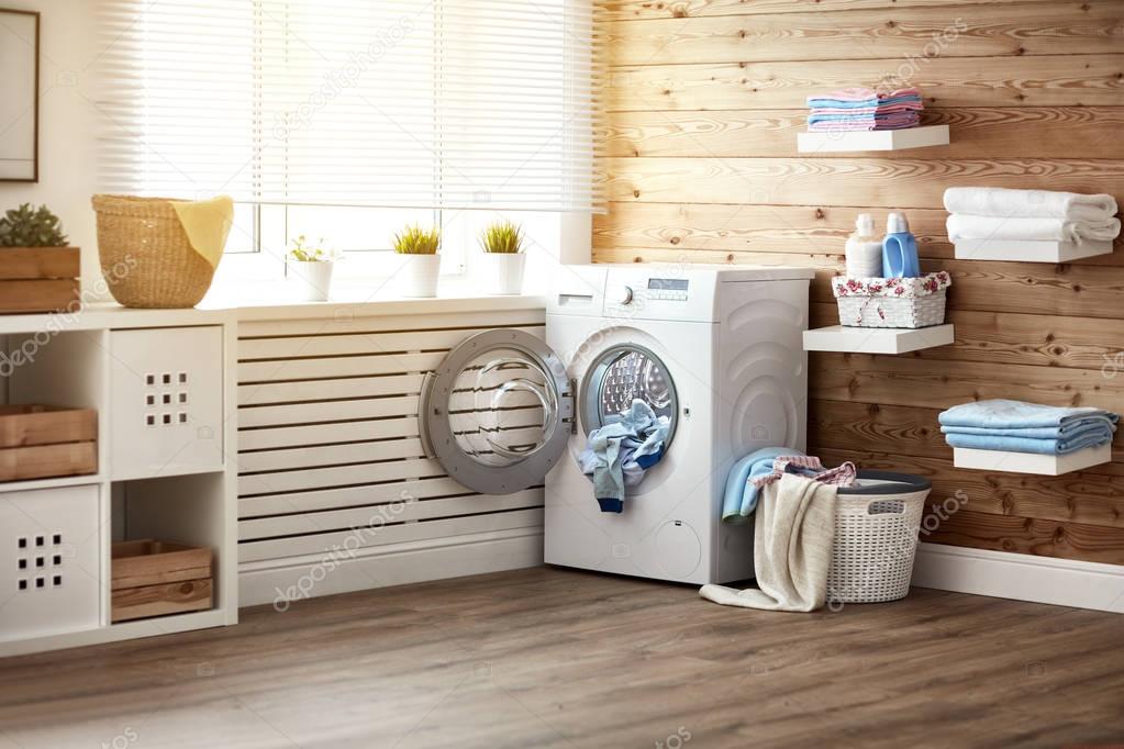 Interior of real laundry room with  washing machine at window at