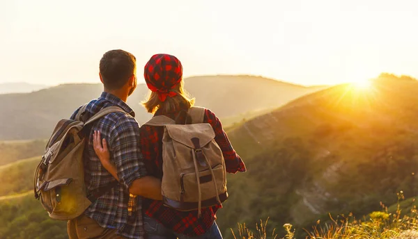 Feliz casal homem e mulher turista no topo da montanha ao pôr do sol — Fotografia de Stock