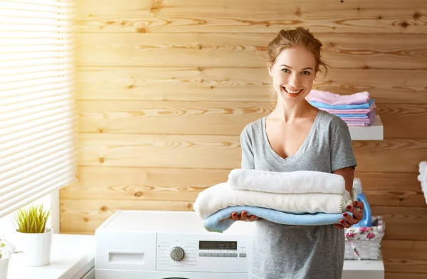 Mujer ama de casa feliz en la sala de lavandería con lavadora — Foto de Stock