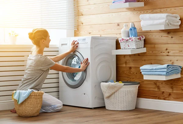 Happy housewife woman in laundry room with washing machine — Stock Photo, Image