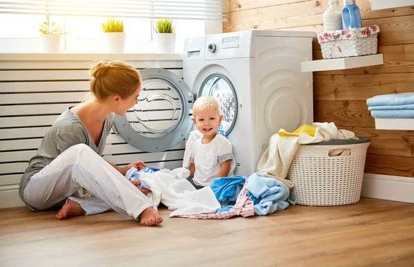 Happy family mother  housewife and children in the laundry load washing machine — Stock Photo, Image