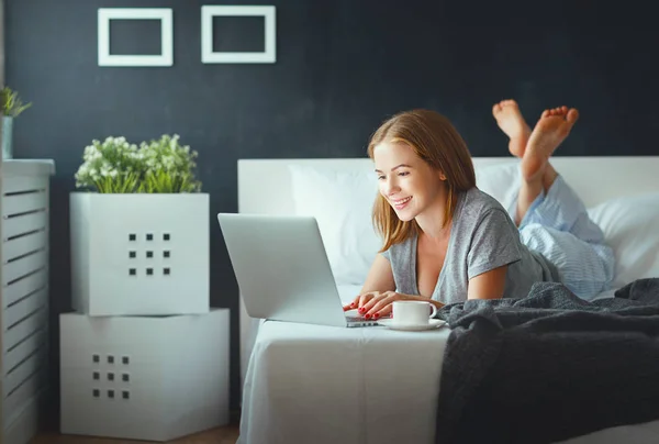 Ung vacker kvinna med laptop och kopp kaffe på morgone — Stockfoto