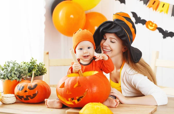 Mãe e bebê cortam abóbora para Halloween na cozinha — Fotografia de Stock