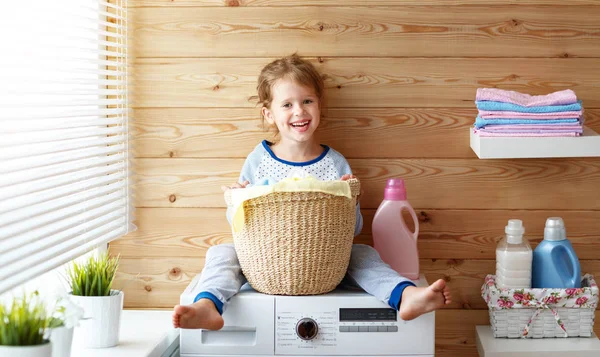Fröhliche kleine lustige Hausfrau Baby-Mädchen in der Wäsche mit Waschen — Stockfoto