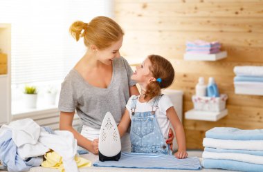 Mutlu aile anne ev hanımı ve çocuk kız elbise Ütü