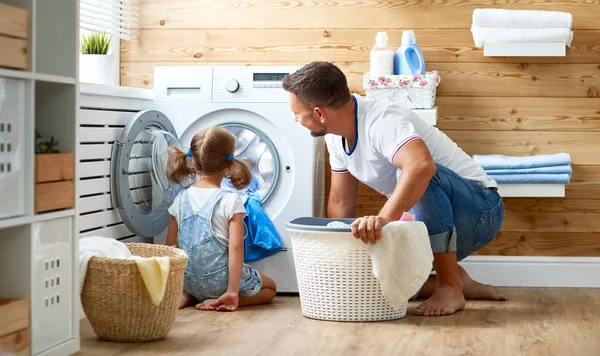 Šťastný otec rodiny hospodáře otec a dítě v prádelně s — Stock fotografie