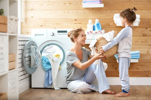 Feliz familia madre ama de casa y el niño en la lavandería con lavabo —  Fotos de Stock