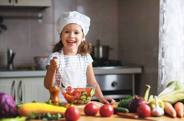 Здоровое питание. Счастливая девочка готовит овощной салат в ки — стоковое фото