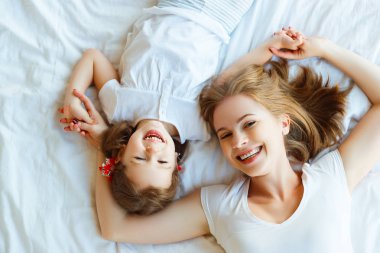  Mutlu aile anne ve çocuk kızı yatakta gülmek
