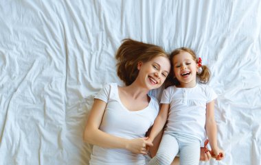 Mutlu aile anne ve çocuk kızı yatakta gülmek