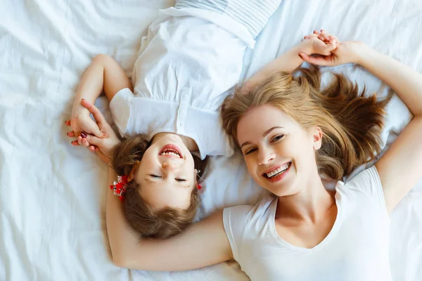 Boldog család anya és lánya gyermek nevetni az ágyban — Stock Fotó
