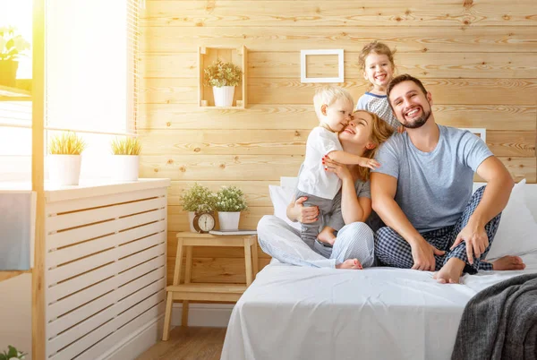 Ευτυχισμένη οικογένεια μητέρα ο πατέρας και τα παιδιά κόρη και γιο στο κρεβάτι — Φωτογραφία Αρχείου
