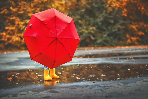 행복 한 아이 우산과 고무 여자에 웅덩이에 부츠 — 스톡 사진