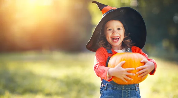 Kind meisje met pompoen buitenshuis in hallowee — Stockfoto
