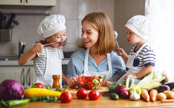 Gezond eten. Gelukkige familie moeder en kinderen bereidt groente salade — Stockfoto