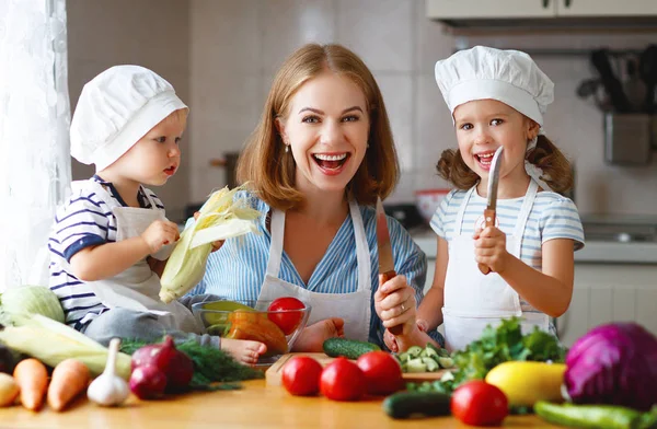 Gesunde Ernährung. glückliche Familienmutter mit Kindern bereitet Gemüsesalat zu — Stockfoto