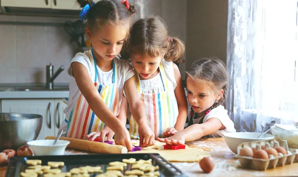 Счастливые сестры дети девочки пекут печенье, месить тесто, играть остроумие — стоковое фото