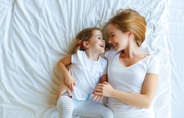  Mutlu aile anne ve çocuk kızı yatakta gülmek