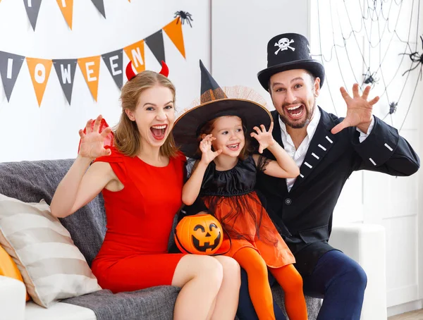 Familia feliz en disfraces preparándose para Halloween en casa — Foto de Stock